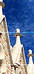 Gothic stone pinnacles and arches of a historic church in El Born, Barcelona, under a blue sky